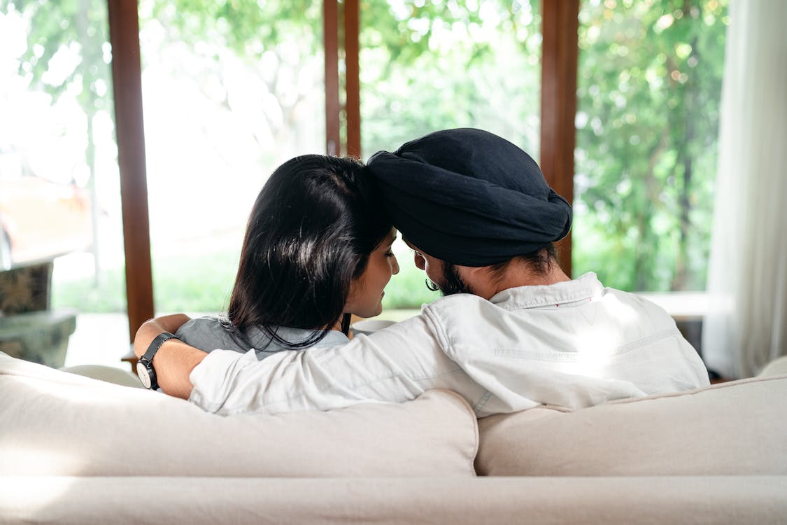 A Heterosexual Couple Cuddling on a Couch Facing the Right Direction According to Vastu
