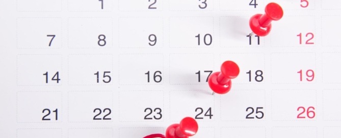 A calendar page marked by red pins and red marker circles.