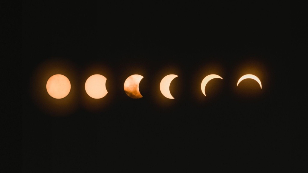 a moon in various phases waning from left to right.
